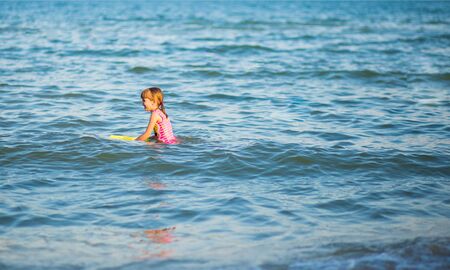 Young little girl with water gun having fun enjoying beach holidayの写真素材