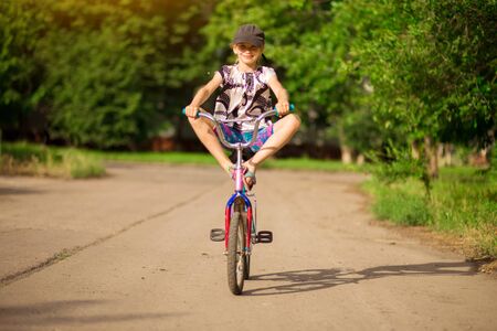 Young little girl learning to ride bike in park. Active childhoodの写真素材