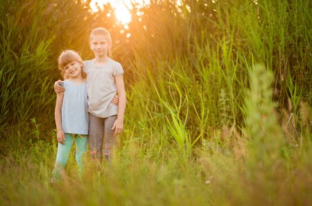 Little kid best friends hugging outdoor at summer sunsetの写真素材