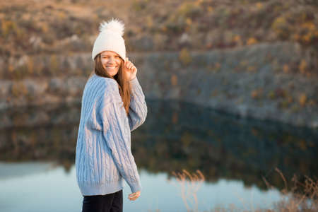 Winter portrait of smilling woman in white hat with big bubo makes funny face outdoorの写真素材
