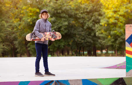 Skater girl on skatepark moving on skateboard outdoors. Copy spaceの写真素材