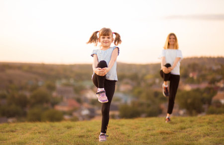 sporty mother and daughter. woman and child training in the park. outdoor sports. healthy sport lifestyle. fitness, yoga.の写真素材