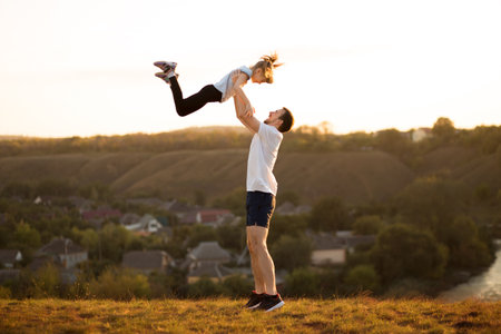 Active family. Father and daughter have fun together. Dad throws his daughter up in skyの写真素材