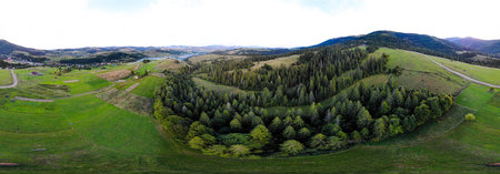 Aerial panoramic banner view of landscape with mountains, green forest and summer meadowの写真素材