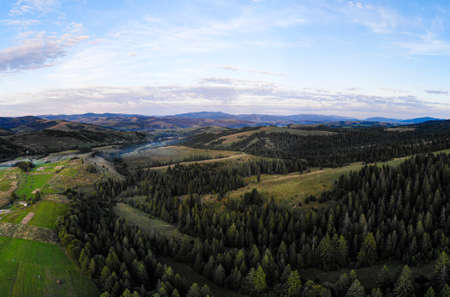 Drone panorama of spring landscape of evergreen forest and mountains with dramatic evening sky viewの写真素材