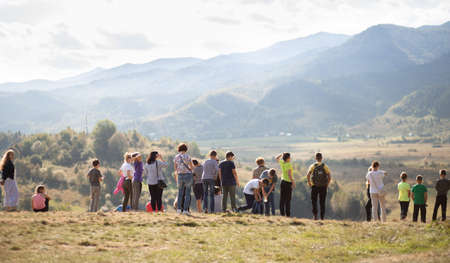 Skidnitsa, Ukraine - 25 September, 2020: Group of school children walk on excursion in mountains over white cloudsのeditorial素材