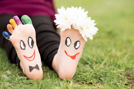 Images of lovely groom and bride just married painted in bright colors on feet of child outdoor at summer. Thinking outside the boxの写真素材