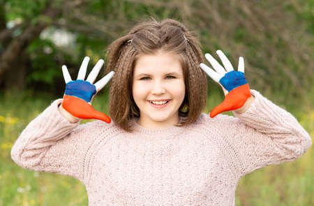 Child girl show hands painted in Russia flag colors walking outdoor. Day of Russian flag. Patriots patriotism citizens nationality. June 12. August 22 holiday. November 4の写真素材
