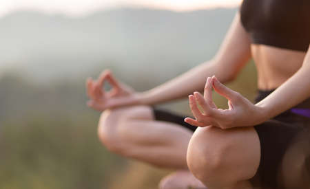 Close up with selective focus of yogi young woman practicing yoga exercises, breathing, meditating, Lotus pose with mudra gesture, working out. Wellbeing, wellness conceptの写真素材
