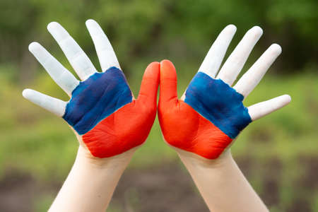 Child show hands painted in Russia flag colors walking outdoor. Day of Russian flag. Patriots patriotism citizens nationality. June 12. August 22 holiday. November 4の写真素材