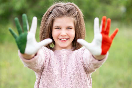 Mexico flag painted on teen girl hands, focus on smile face. Mexican Independence Day 16 September. February 5 Day of Conference. February 24 National Flag Dayの写真素材