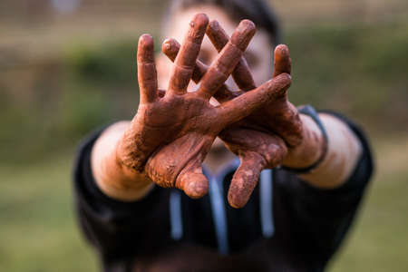 Man show two dirty in clay hands making stop gesture. Worker Hands. Selective focusの写真素材