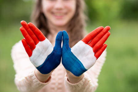 Croatia flag painted on child hands. Girl with open hands raised, focus on hands. Patriotic holiday. Independence Day, 25 June. Selective focus. Croatia Independence Day concept. Victory and Homeland Thanksgiving Day, 5 August, 15 August. Green grass background.の写真素材
