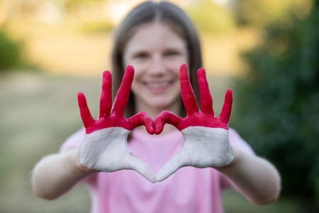 Kid hands in heart form painted in flag Monaco or Indonesia, focus on hands. Tourist made gesture by indonesia flag colored hands showing symbol of heart and love. Indonesian Independence Day, Hari Kemerdekaan Indonesia, 17 August. National Day of Monaco 19 Novemberの写真素材