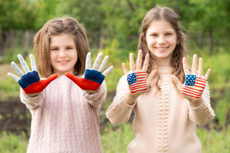 Friendship of peoples, exchange of students. Learning foreign languages. Child hands painted in American and Russian flag color, focus on hands. Relations between Russia and the United States. Concept of friendship relations between Russia and USA.の写真素材