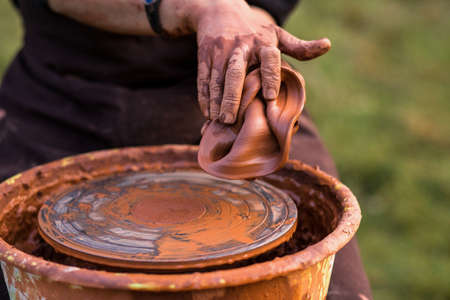 Selective focus. Sculptor man hands ruined a clay vase working by potter wheelの写真素材
