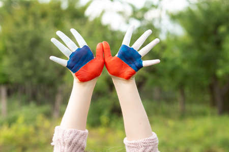 Child show hands painted in Russia flag colors walking outdoor. Day of Russian flag. Patriots patriotism citizens nationality. June 12. August 22 holiday. November 4の写真素材