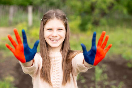Hands of kid girl painted in Mongolia flag color. July 10 National Flag Day. Mongolian memorial holiday 29th of Decemberの写真素材