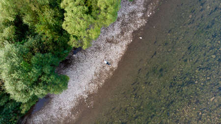 Aerial drone view from above of young woman lying on beach of sea. Space for text.の写真素材