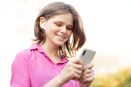 Overjoyed pretty girl wears in pink get carry away with music. Asian teenager girl use smartphone and enjoy favorite playlist via stereo headphones, relaxed sings along with carefree expression. High quality photoの写真素材