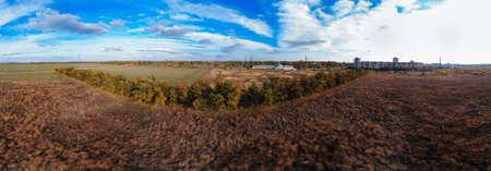 Aerial view of landscape at autumn time, drone image. City landscape. View of city meadow from above. Beautiful nature panorama in autumn with orange and yellow foliage.の写真素材