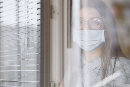 The girl in isolation near the window, coronavirus, covid-19の写真素材