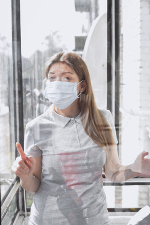 The girl in isolation near the window, coronavirus, covid-19