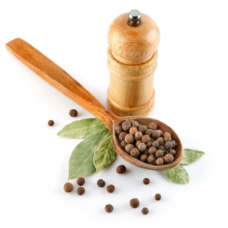 spices in wooden spoon with laurel leaves isolated on white backgroundの写真素材