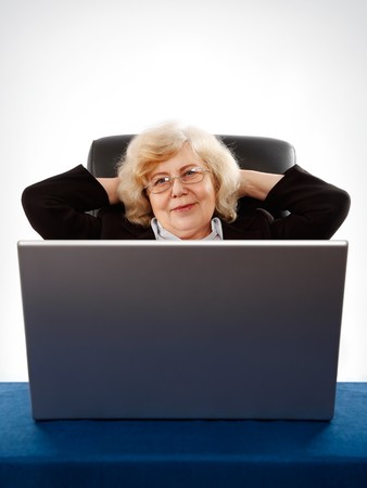 elderly businesswoman sitting in armchair by the laptopの写真素材