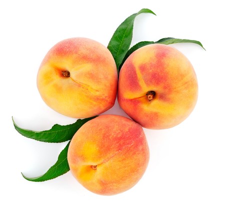 fresh peach fruits with green leaf isolated on white backgroundの写真素材