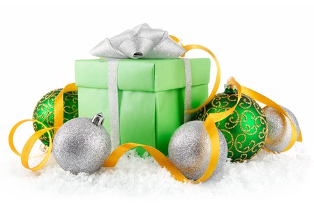 gift in snow with bow and  green balls isolated on white backgroundの写真素材