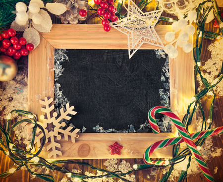 Christmas background with board in wooden frame and garlandの写真素材
