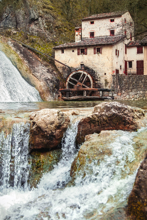 Old ancient mill Vecchio Mulino della Croda at flowing stream in Refrontolo town, Veneto region, Prosecco, Italy. Spring landscape with flowing water over stonesの写真素材