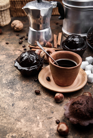 Crafting coffee in clay cup with bean cezve and chocolate cake top view on grungeの写真素材