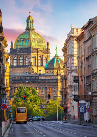Street in Prague, Czech Republic. Cityscape with road and view at dome of national museum building. Transport and bus at crossroad. Dawn early morning in centre of city.の写真素材