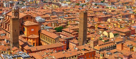 Bologna, Italy. Top view of old town with terracotta houses, streets, towers, ancient cathedral and housetops. Sunny day urban italian landscape.の写真素材