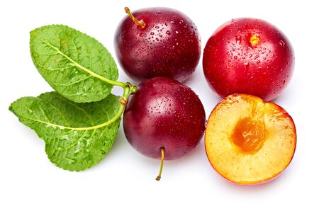 Fresh plum in cut with green leaf. Fruity still life. Healthy food. Isolated on white background.の写真素材