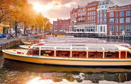 Amsterdam, Holland, Netherlands. Amstel river, canals and boats against evening dusk sunset sky cityscape.の写真素材