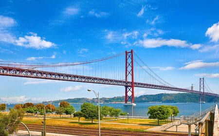 25th April Bridge in Lisbon, Portugal. Famous landmark on river Tagus. Summer sunny landscape with blue sky.の写真素材