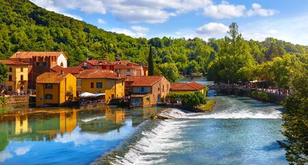 Italian traditional village with vintage colorful houses above riverの写真素材
