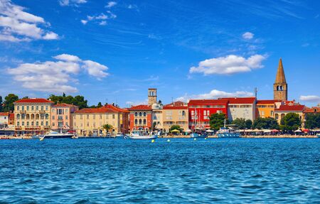 Porec, Croatia. Antique tower in old town. Istria peninsula in Adriatic Sea. View from water at old Mediterranean architecture buildings. Coastline and tower of Church.の写真素材