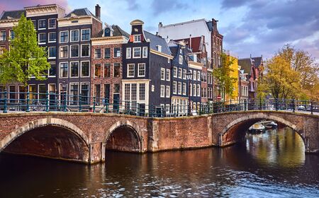 Bridge over channel in Amsterdam Netherlands houses river Amstel landmark old european city spring landscape.の写真素材