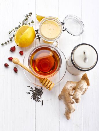 Ginger tea with lemon honey Rose Hip and thyme at white wooden board in rustic style. Top view.の写真素材