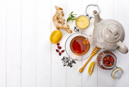 Cup tea with honey lemon and Rose Hip on white wooden board top view. Medicinal drink with mint and ginger.の写真素材