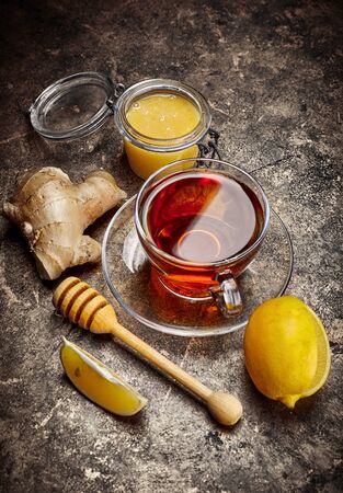 Cup black tea with ginger honey and lemon on metallic surface top view. Still life of hot therapeutic drink from cold.の写真素材
