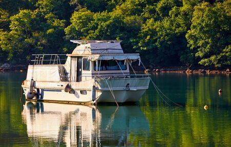 Bay of Lim, peninsula Istria, Croatia. Fishing boat for growing and catching oysters. Salty lake bay oyster farms among hills covered with green forest. Picturesque summer landscape with blue sky.の写真素材