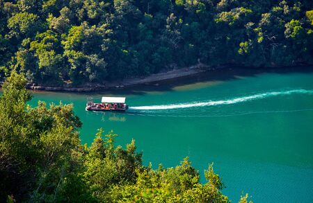 Bay of Lim, peninsula Istria, Croatia. Fishing boat for growing and catching oysters. Salty lake bay oyster farms among hills covered with green forest. Picturesque summer landscape with blue sky.の写真素材