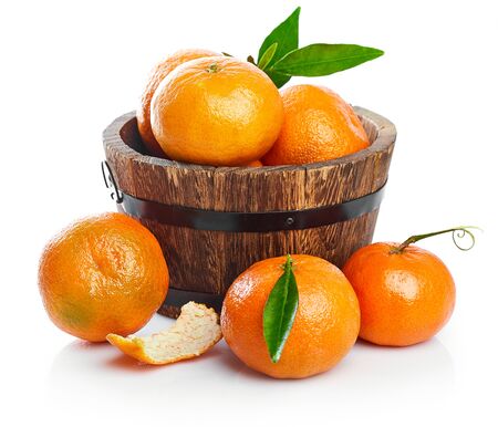 Harvest tangerines in wooden basket with green leaves. Fruity still life with fresh fruit. Isolated on white background.の写真素材