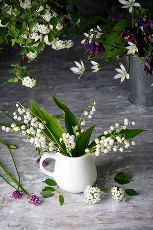Bouquet spring white Lily of the valley. Floral still life on gray wooden board table in rustic style. Blooming branch bush with flowerbed gardening flower-growing.の写真素材