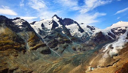 Panoramic view at Pasterze Glacier Grossglockner among austrian Alps mountains summits blue sky clouds.の写真素材